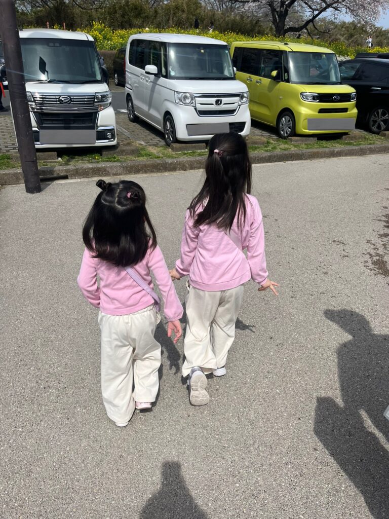 小さな女の子が2人で歩いている後ろ姿の写真です。