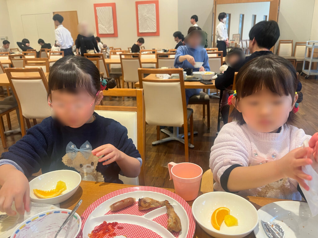 ホテルのレストランで朝食バイキングを食べる姉妹の画像です。